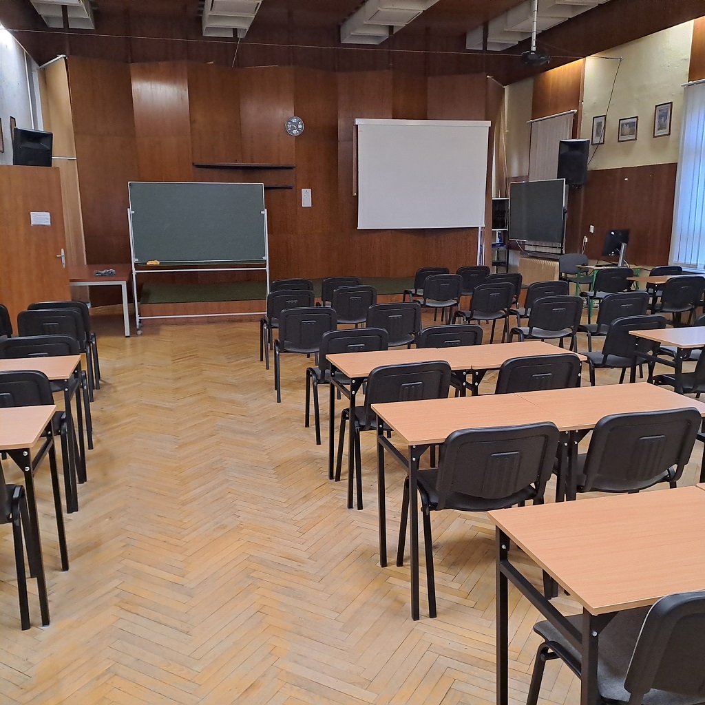Aula XIV LO w Szczecinie przed rozpoczęciem prac - zniszczony parkiet, na którym stoją ławki szkolne