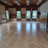 Aula XIV LO w Szczecinie po zakończeniu prac - parkiet jest odnowiony i błyszczy w słonecznym świetle