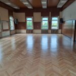 Aula XIV LO w Szczecinie po zakończeniu prac - parkiet jest odnowiony i błyszczy w słonecznym świetle